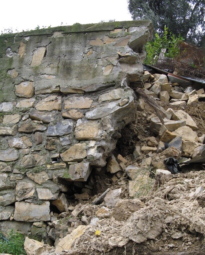 muro a secco di confine franato a seguito di infiltrazione d'acqua
